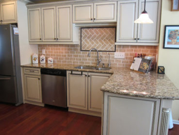 Whitewashed Brick Backsplash Tile With White Kitchen Cabinets